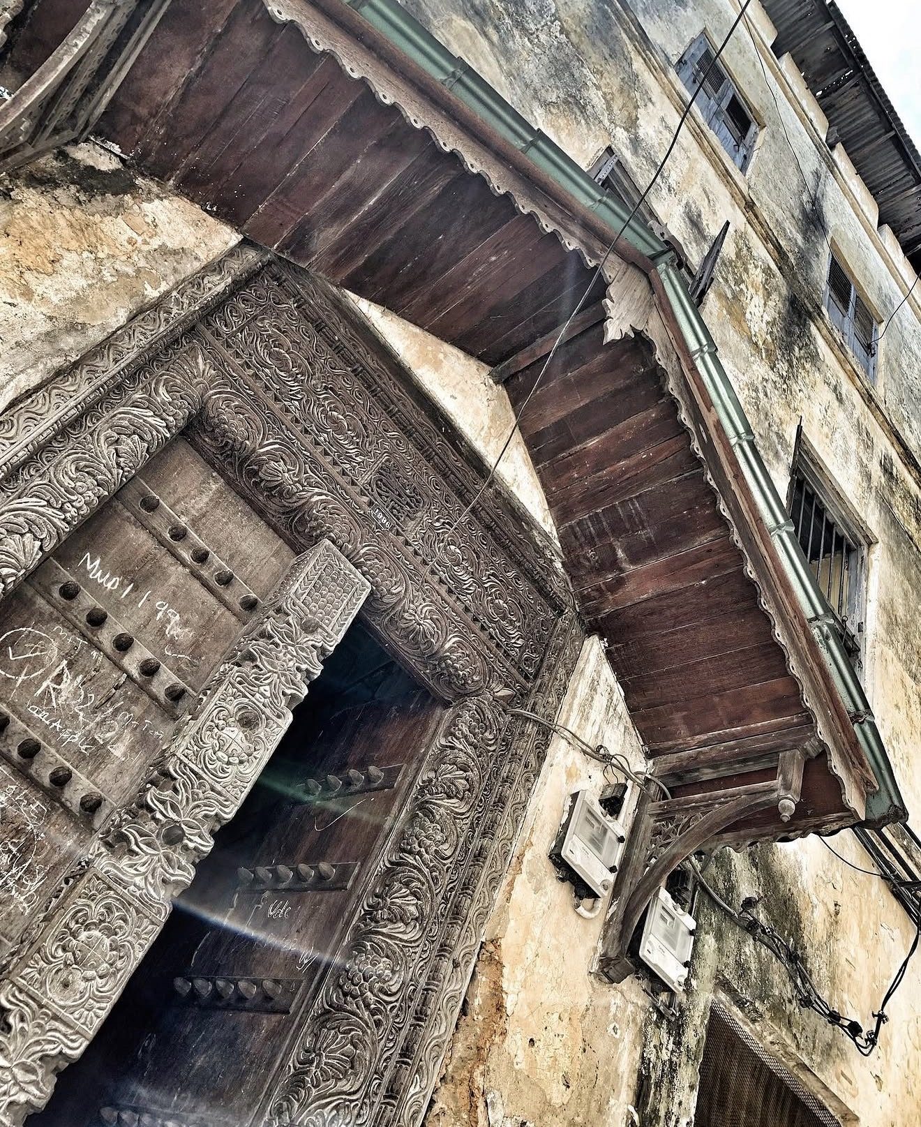 A carved wooden door and balcony in Bagamoyo's old town